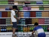 Liu Bolin...Chinese artist Liu Bolin, center, is helped by his colleagues as painted to blend into rows of drinks in his artwork entitled "Plasticizer," to express his speechlessness at use of plasticizer in food additives, in his studio at the 798 Art District in Beijing, China, Wednesday, Aug. 10, 2011. (AP Photo)